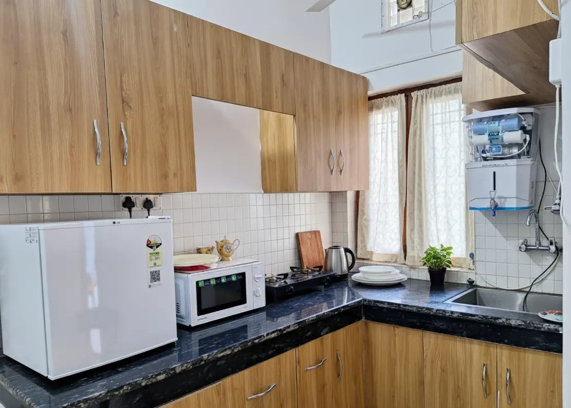 Fully equipped in-room kitchen with fridge, stove and water purifier